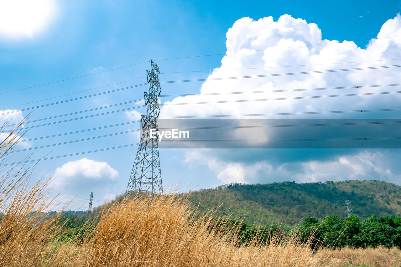LOW ANGLE VIEW OF ELECTRICITY PYLONS ON LAND AGAINST SKY