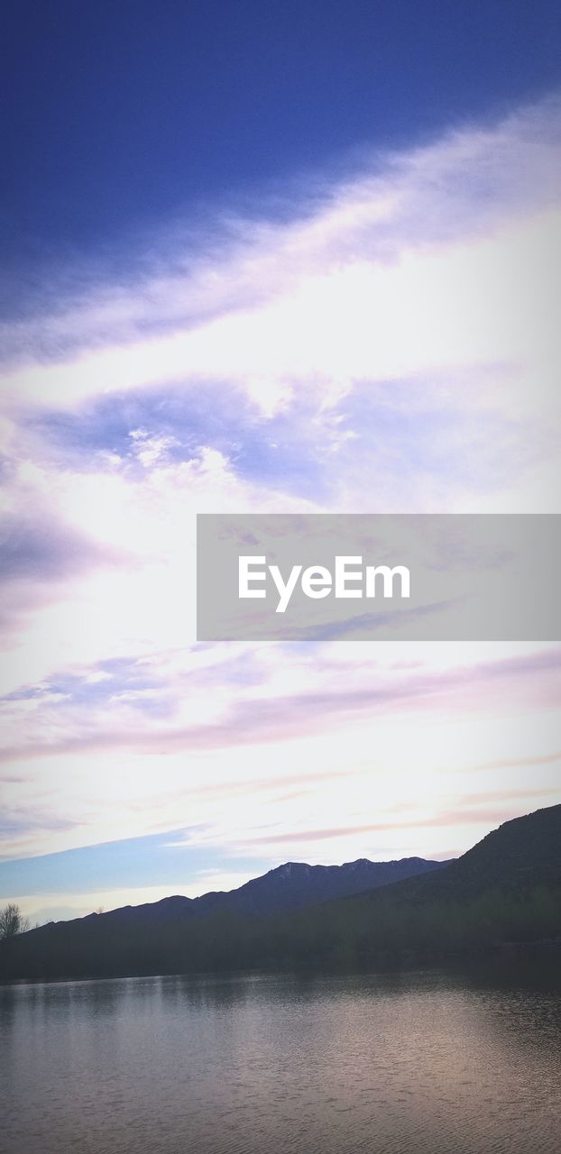 SCENIC VIEW OF LAKE BY MOUNTAIN AGAINST SKY