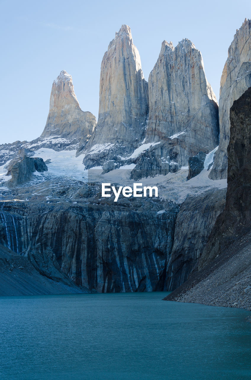 Scenic view of lake and snow covered mountains against sky