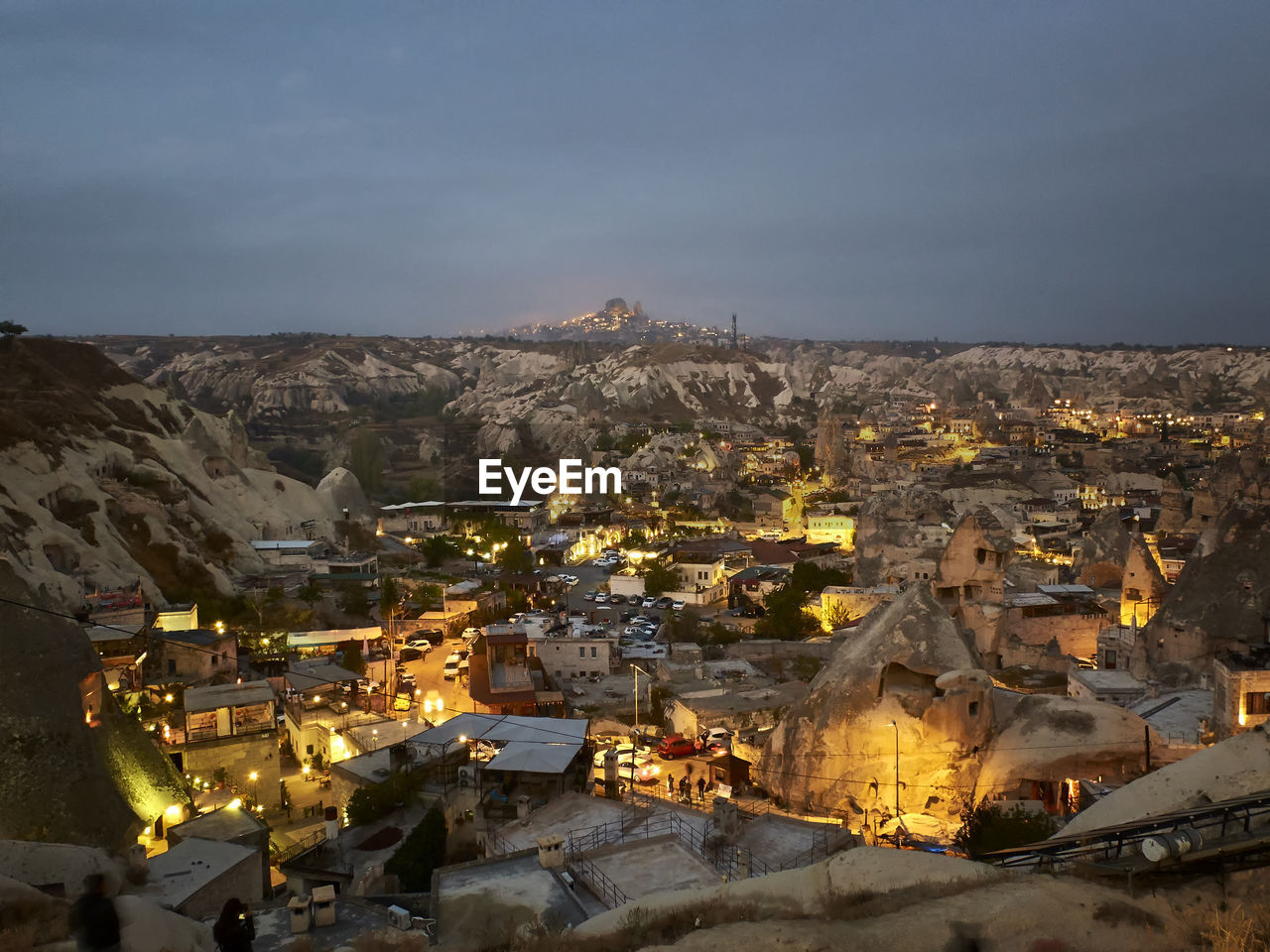 Cave houses and volcanic landscape of cappadocian town goreme and uchisar castle at the horizon