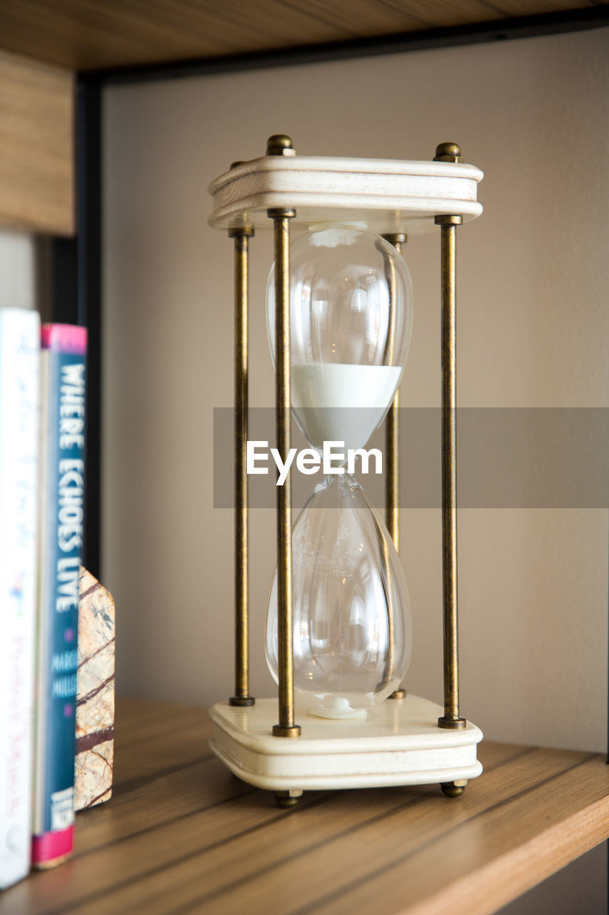 Hourglass on wooden shelf