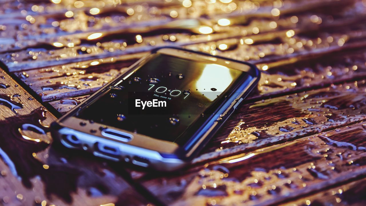 Close-up of mobile phone on wet table