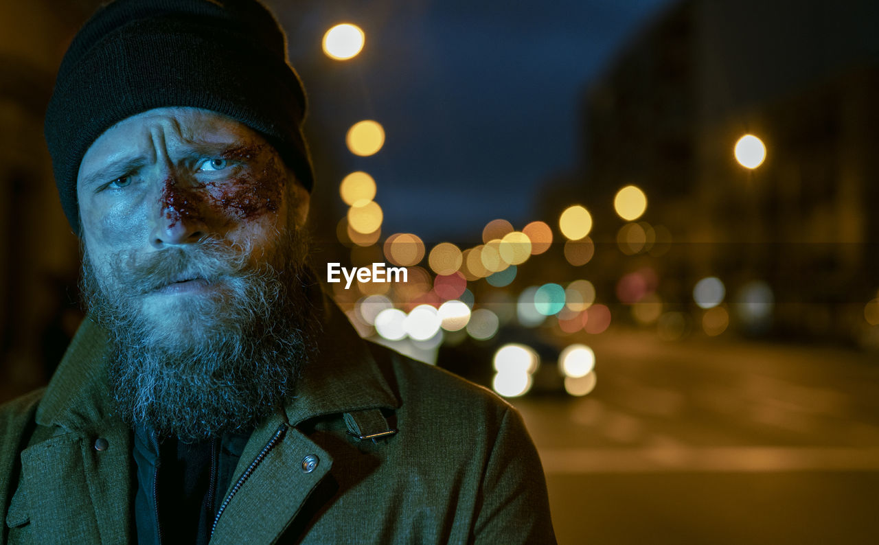 Hipster man with beard and cinema makeup posing on the street