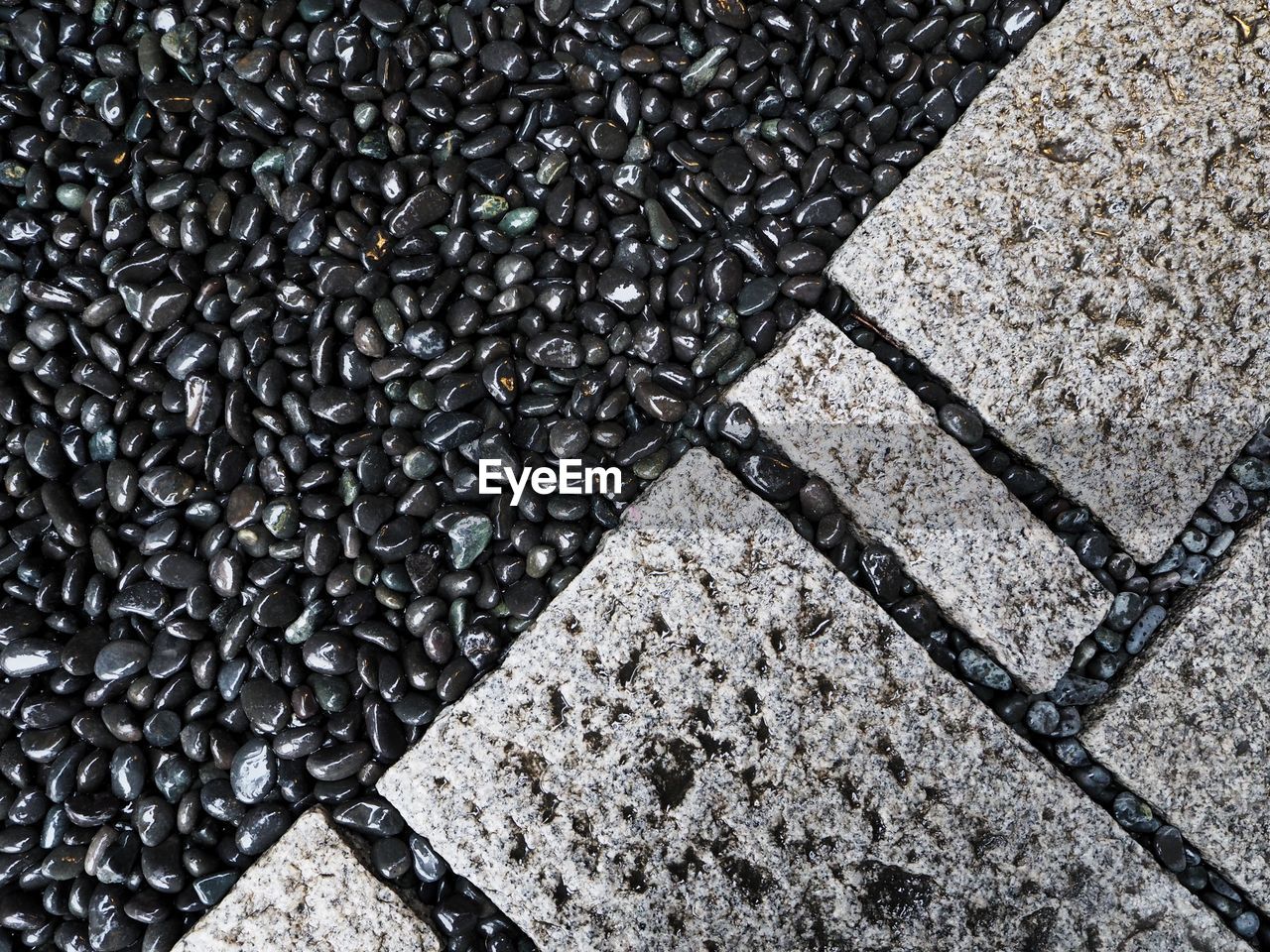 HIGH ANGLE VIEW OF STONES ON CONCRETE SURFACE