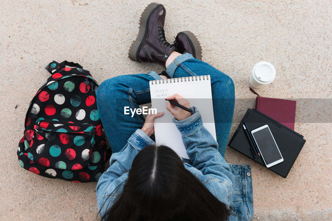 Top view of a college student while she writes in her notebook