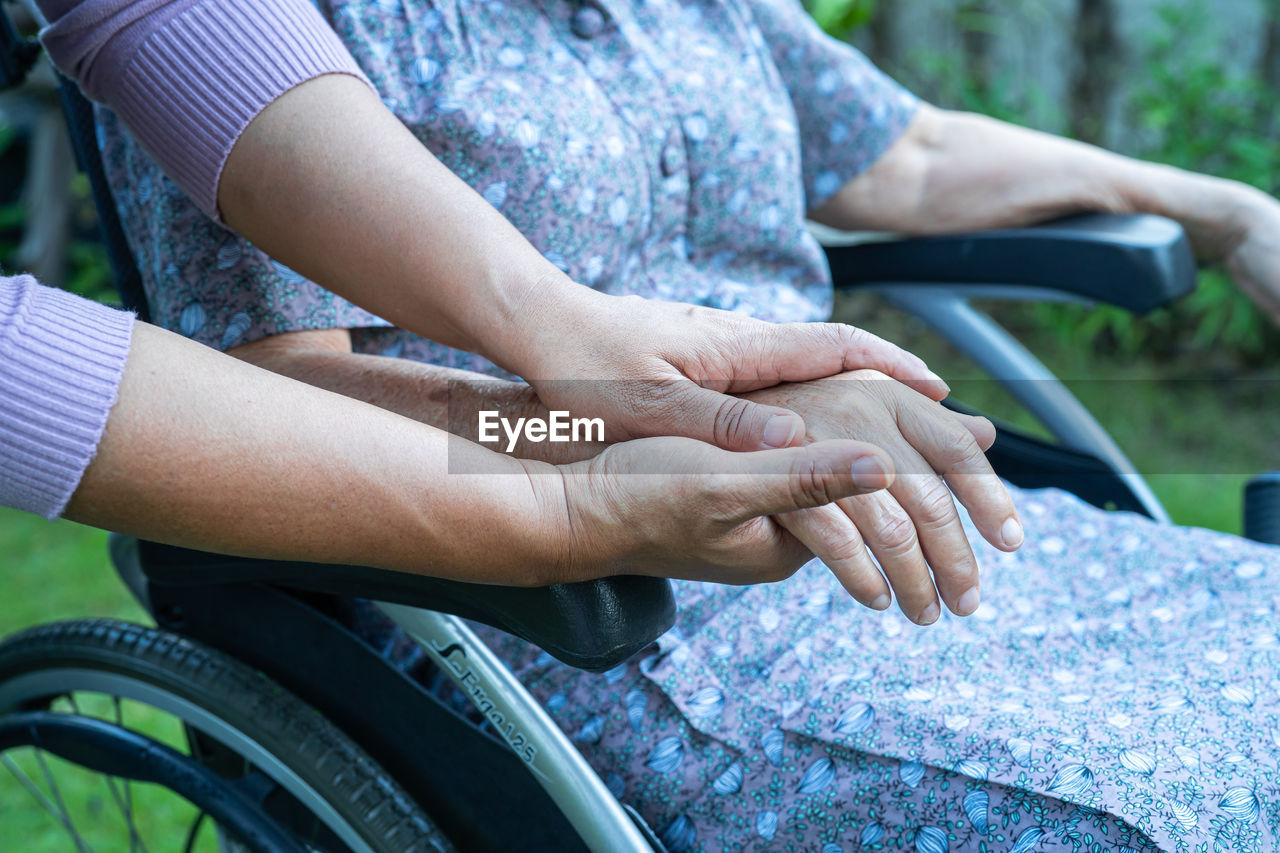 Cropped hands of nurse consoling patient