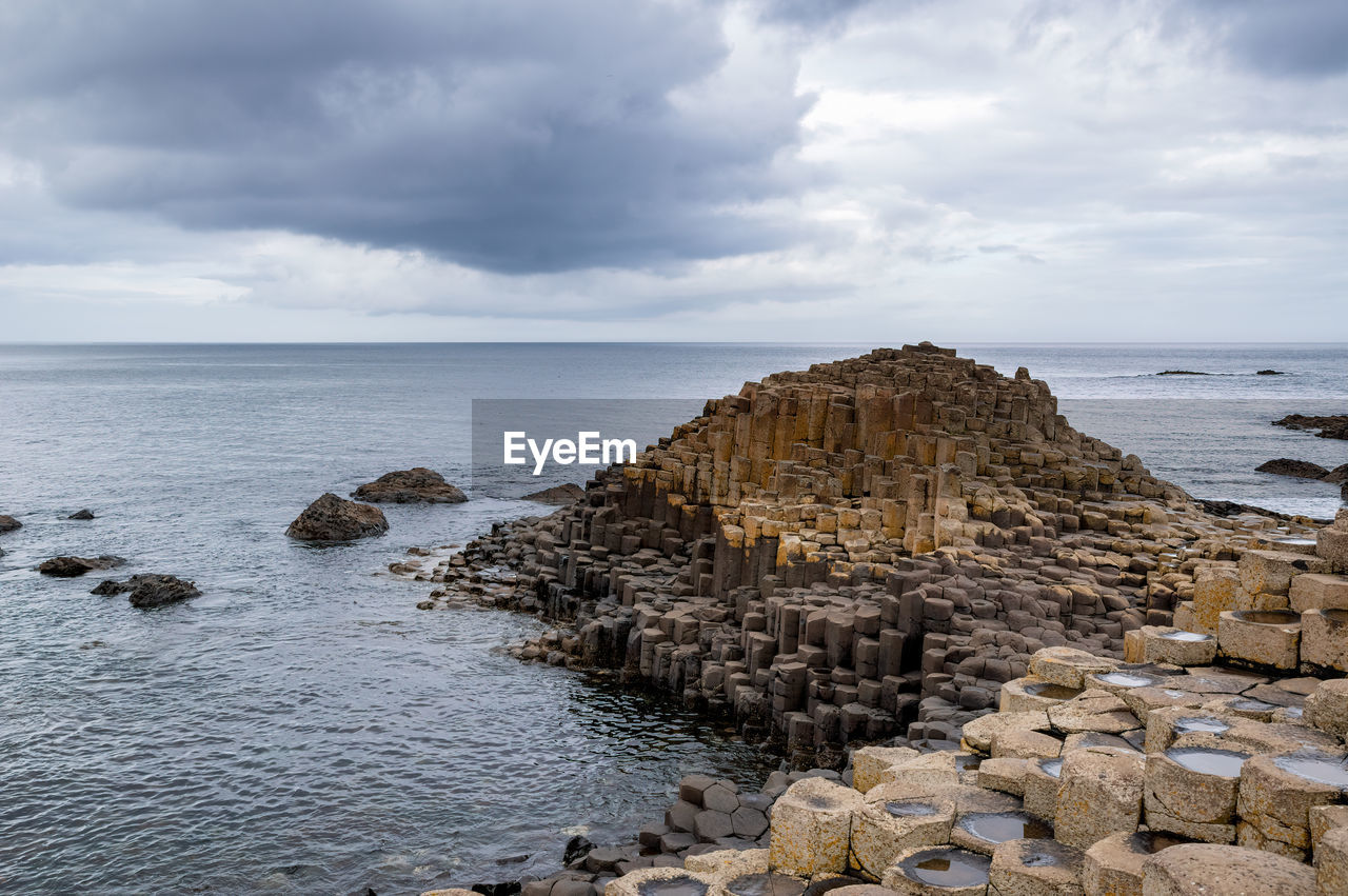 SCENIC VIEW OF ROCKS ON BEACH AGAINST SKY