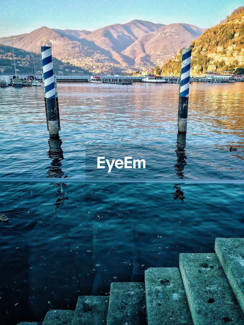 Boats moored on sea against mountains