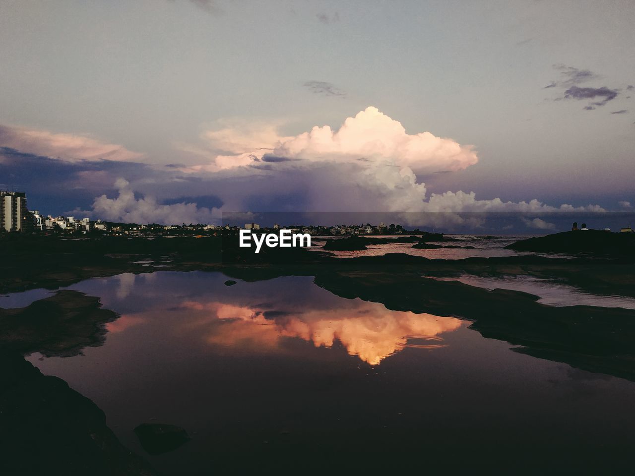 REFLECTION OF SKY ON LAKE AT SUNSET