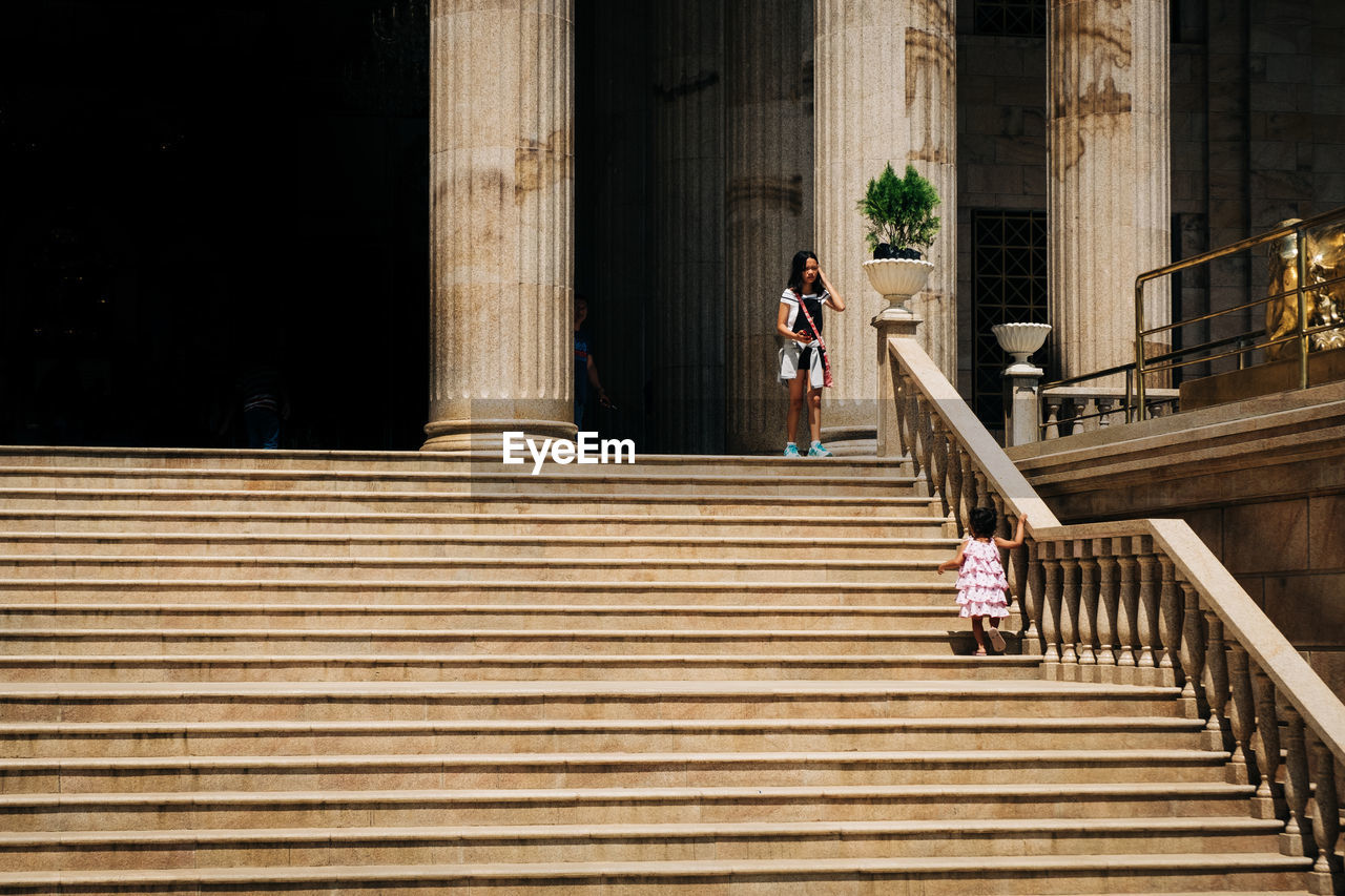 LOW ANGLE VIEW OF PEOPLE ON STAIRCASE AT BRIDGE