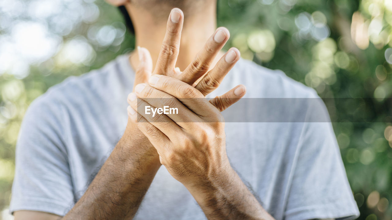 Midsection of man holding hand outdoors