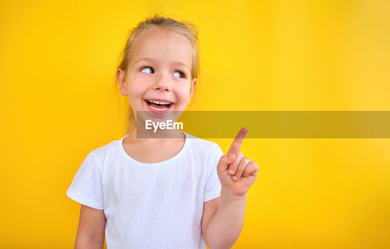 Adorable preschool girl showing pointing at copy space advertising sale announce
