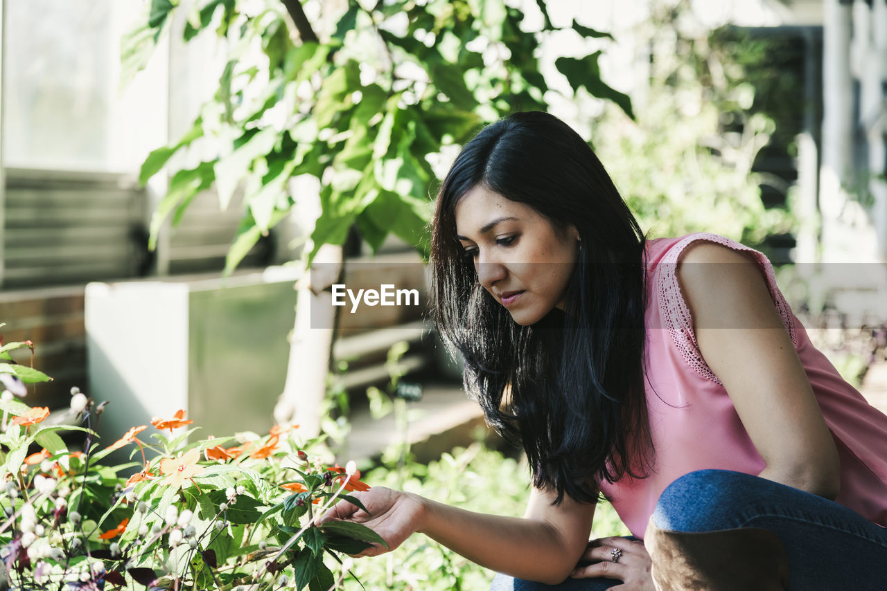 Beautiful agronomical engineer observing the plants in the greenhouse