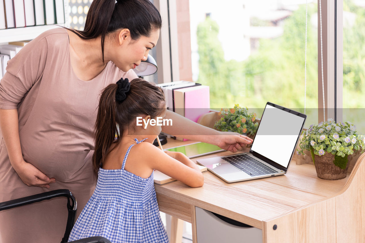 WOMAN USING PHONE ON TABLE