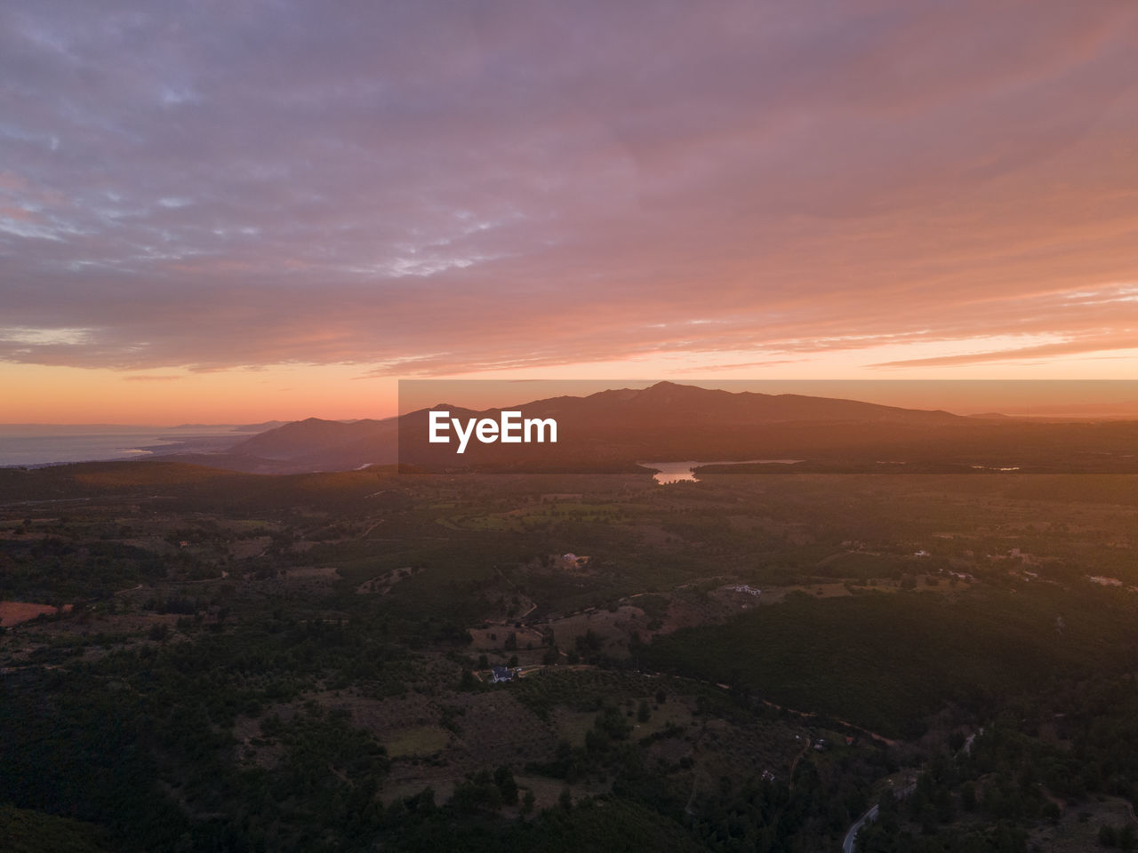 HIGH ANGLE VIEW OF TOWNSCAPE AGAINST SKY AT SUNSET