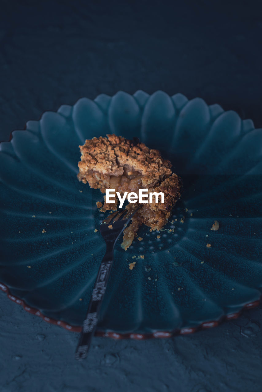 Close-up of half eaten apple pie on a blue platter