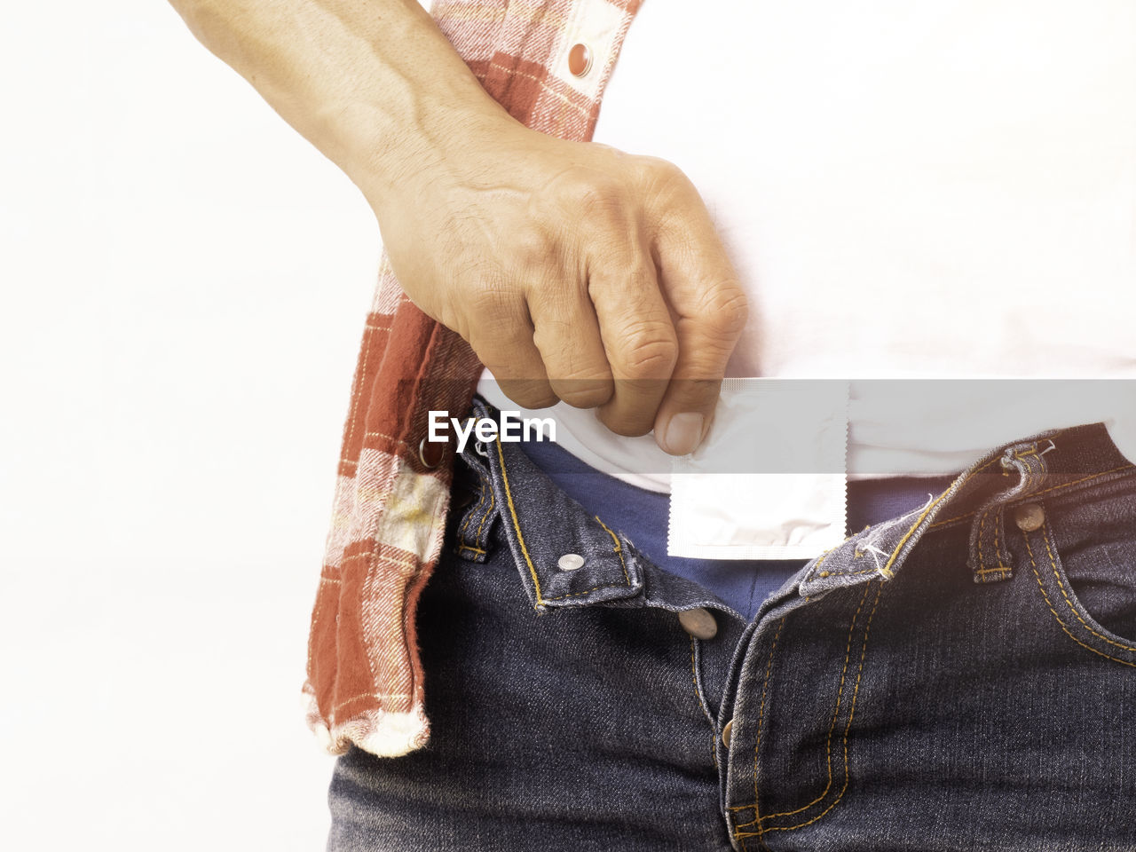 CLOSE-UP OF MAN HOLDING CIGARETTE OVER WHITE BACKGROUND