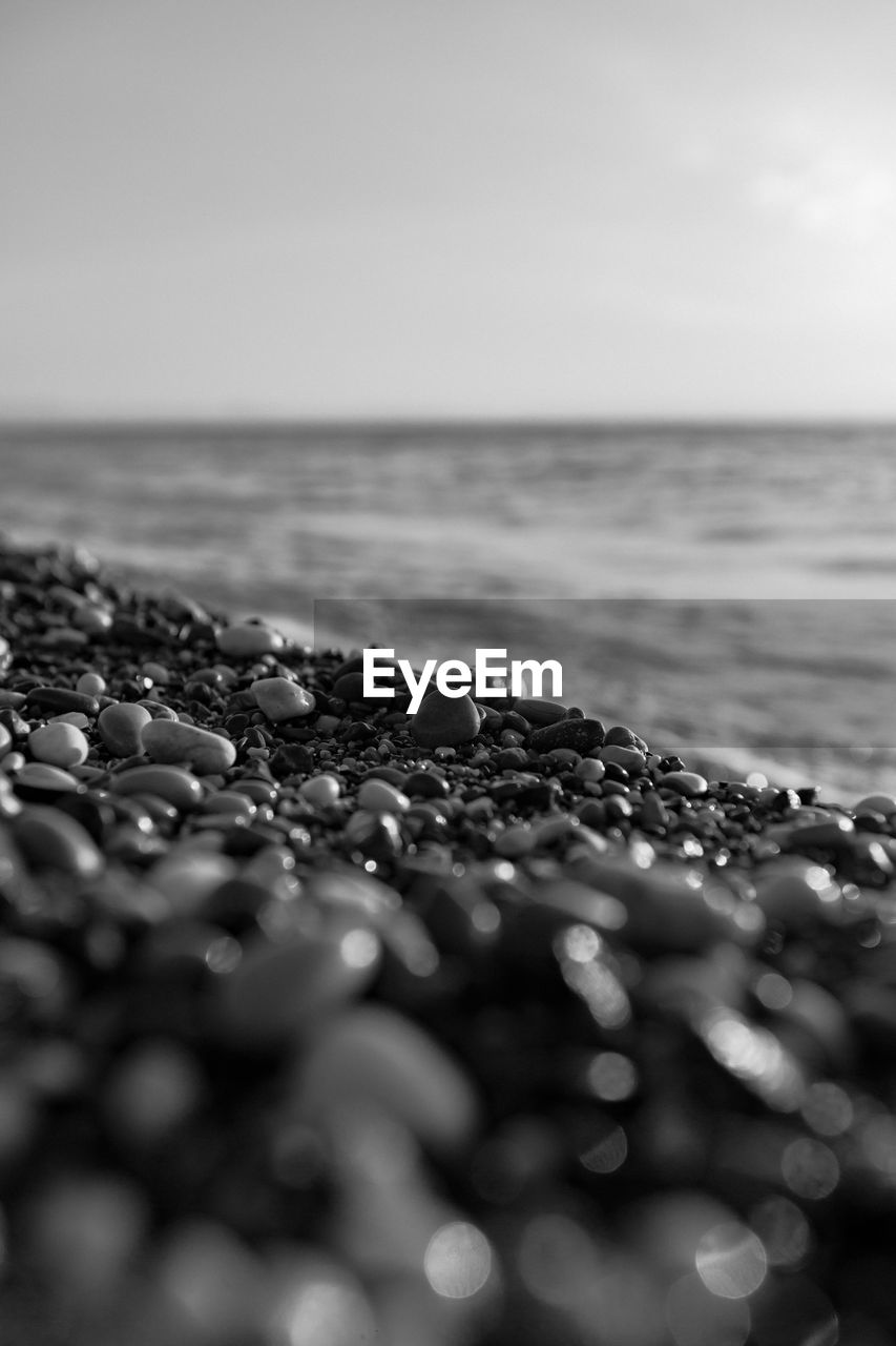 black and white, water, sea, monochrome, monochrome photography, black, sky, land, nature, horizon, beach, horizon over water, close-up, selective focus, wave, no people, beauty in nature, tranquility, rock, white, sand, scenics - nature, outdoors, macro photography, ocean, motion, sunlight, environment