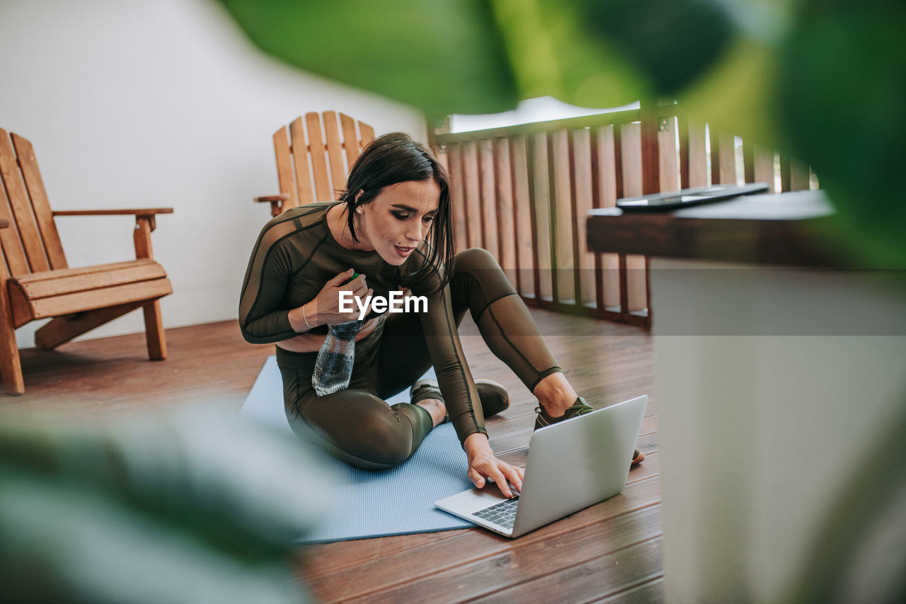 Woman using phone while sitting on table
