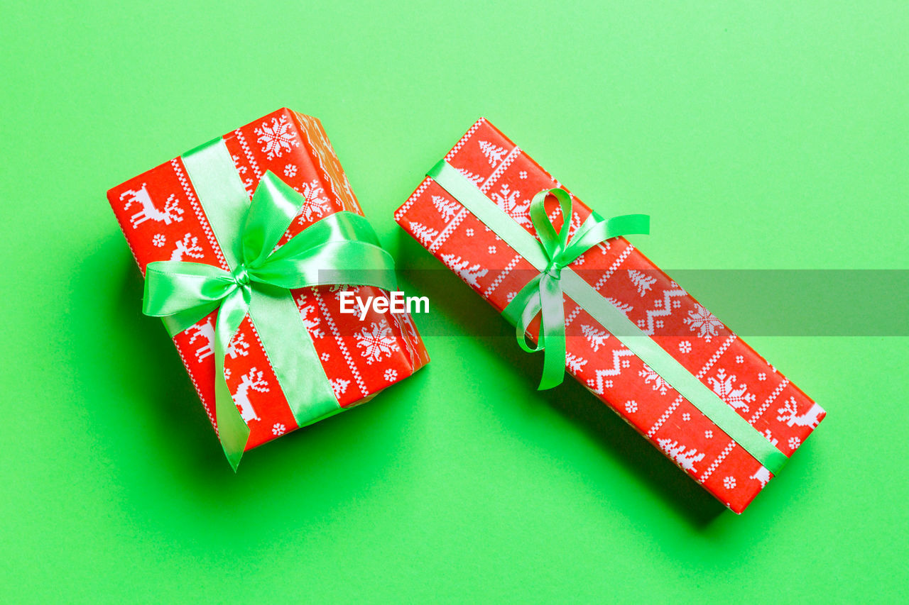 Holiday handmade present in paper on colorful background. present box on colored table, top view.