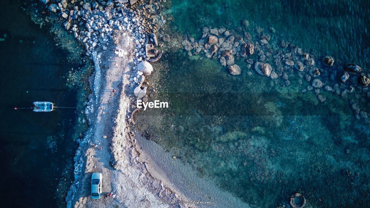 HIGH ANGLE VIEW OF PEOPLE SWIMMING ON SEA