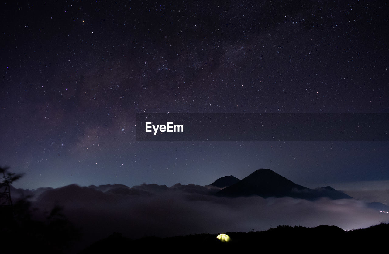 Low angle view of silhouette mountain against sky at night