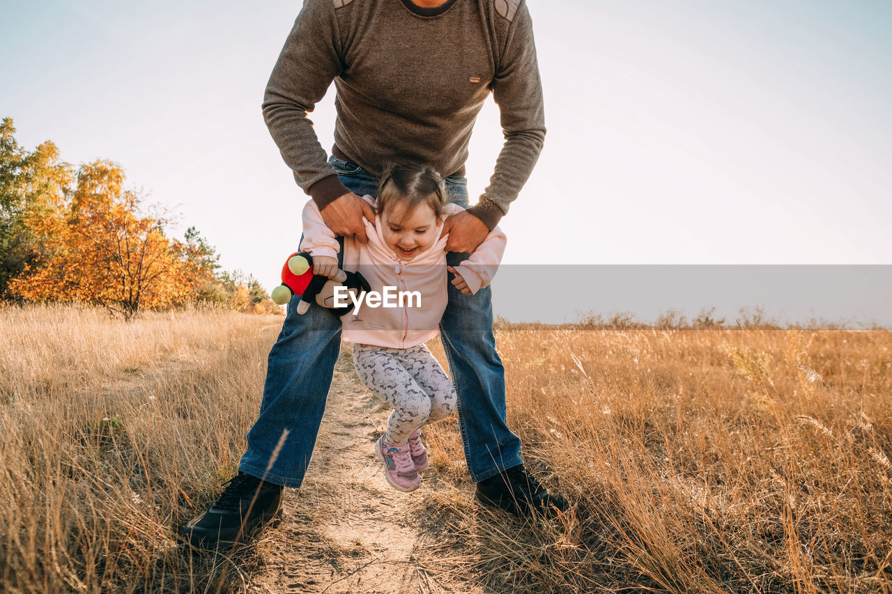 Father and child having fun playing outdoors. dad and daughter spending time together, relaxing 