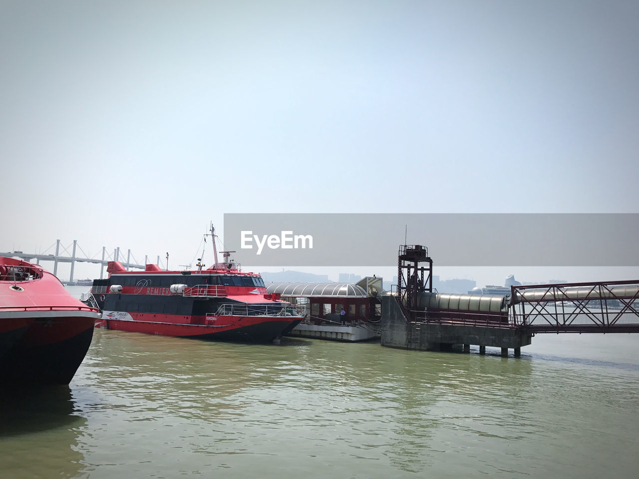 BOATS MOORED IN RIVER AGAINST SKY