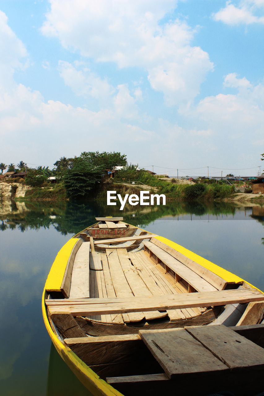 BOAT MOORED ON LAKE AGAINST SKY