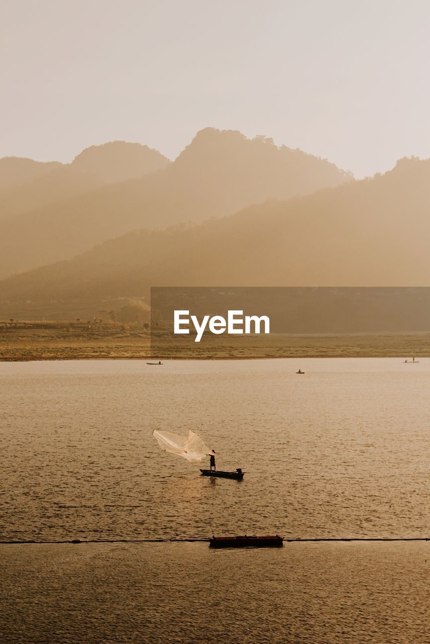 SCENIC VIEW OF SEA BY MOUNTAINS AGAINST SKY