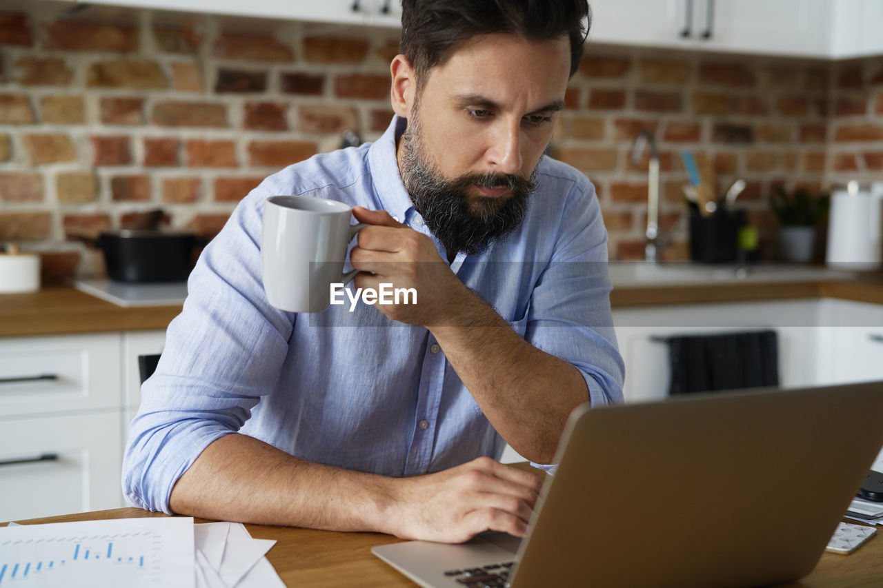 Businessman man holding coffee cup working at office