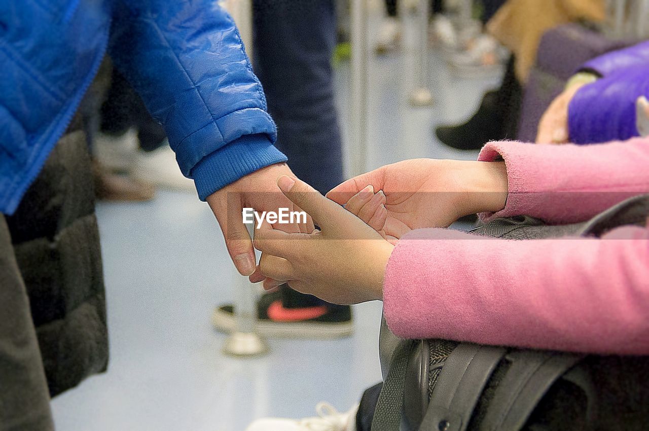 Cropped image of couple holding hands at subway station