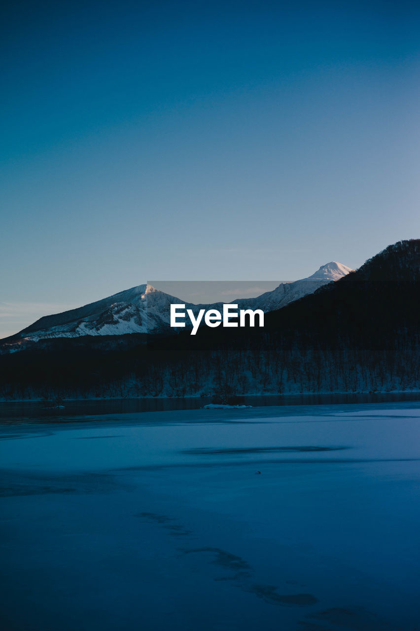 Scenic view of snowcapped mountains against clear sky