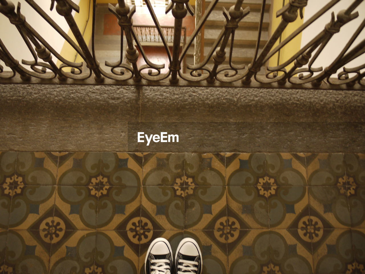 High angle view of shoes on tiled floor by railing