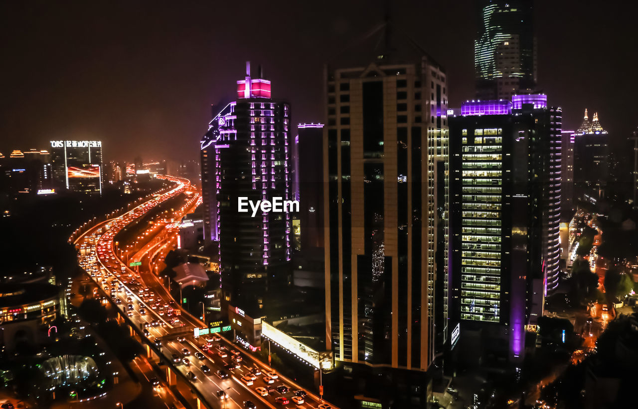 Illuminated cityscape against sky at night