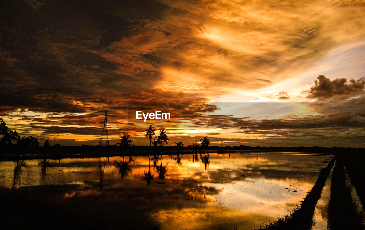 SCENIC VIEW OF LAKE AGAINST SKY DURING SUNSET