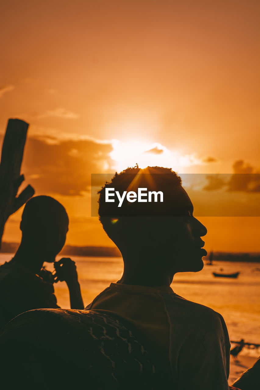 Friends hanging out at the beach during sunset