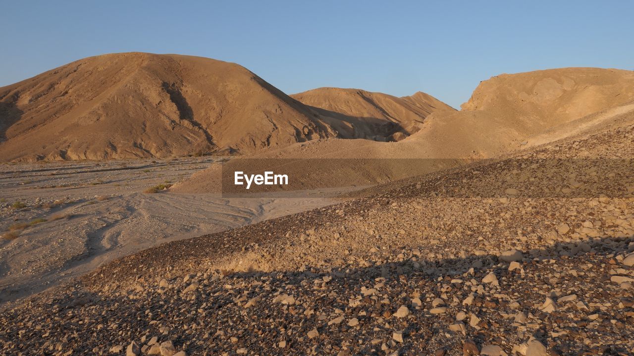Scenic view of arid desert against sky at sunrise 