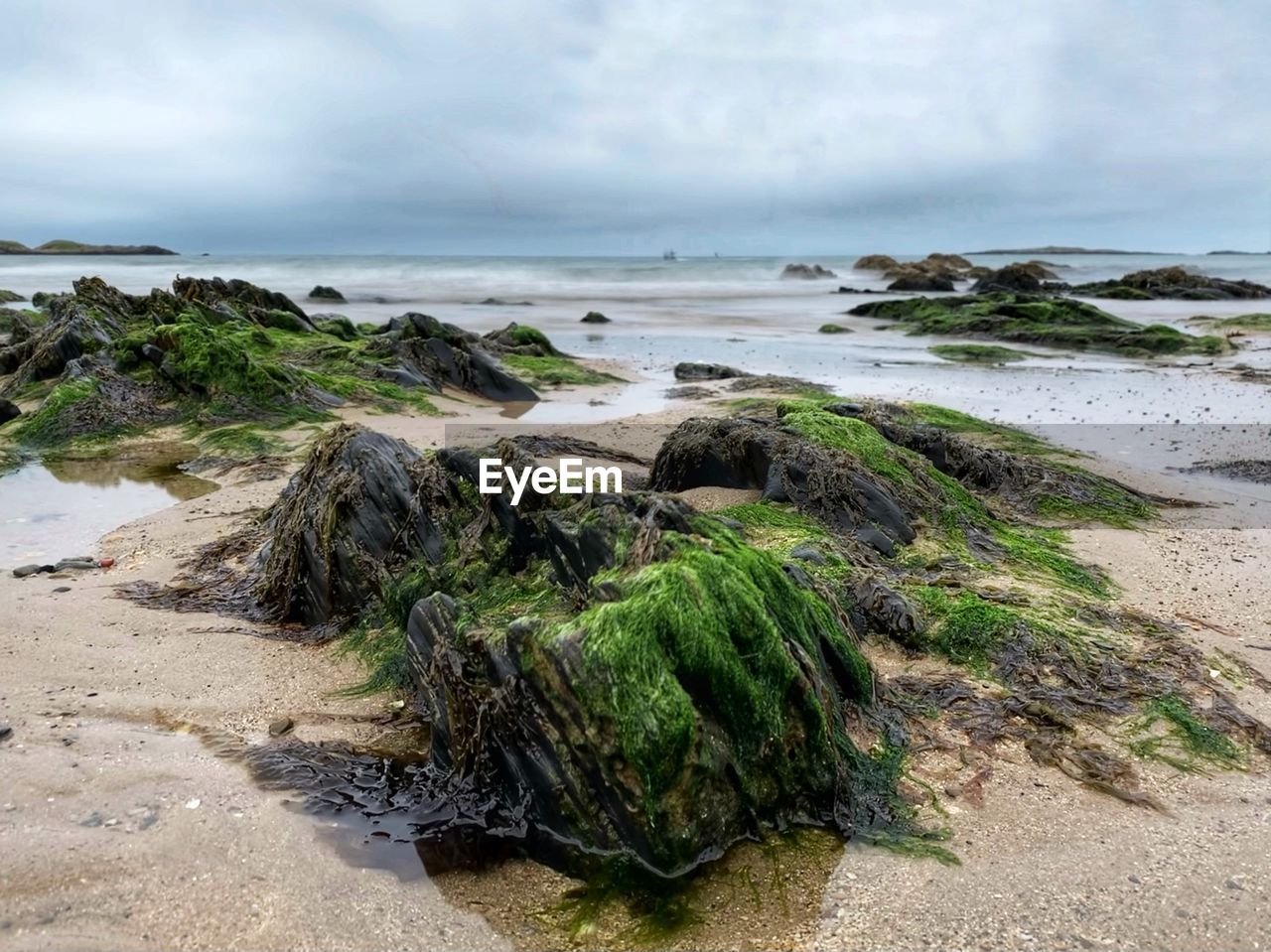 ROCKS ON BEACH AGAINST SKY