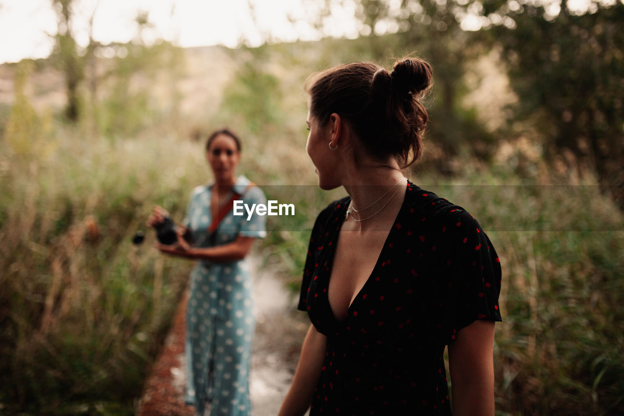 Lesbian couple standing by plants on land