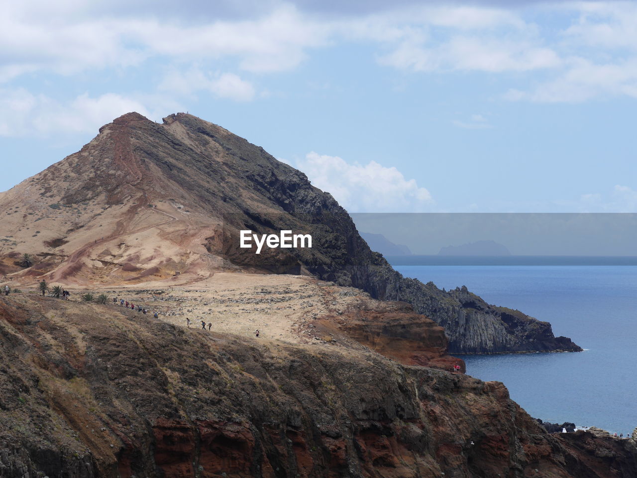 Scenic view of rocky mountains and sea against sky