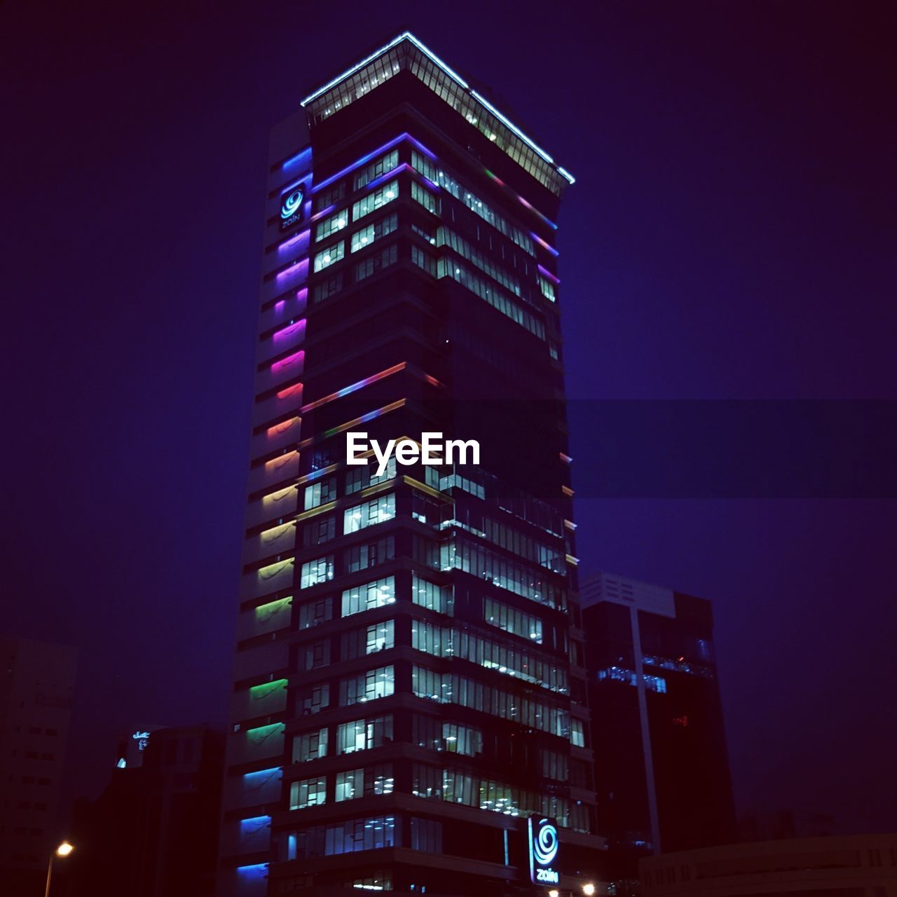 LOW ANGLE VIEW OF ILLUMINATED SKYSCRAPERS AGAINST SKY