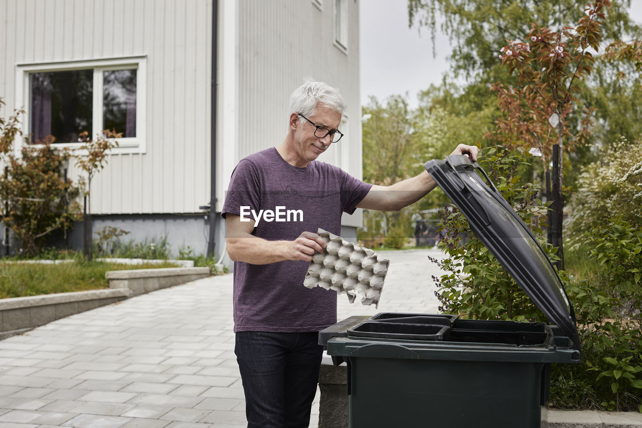 Man putting rubbish into bin