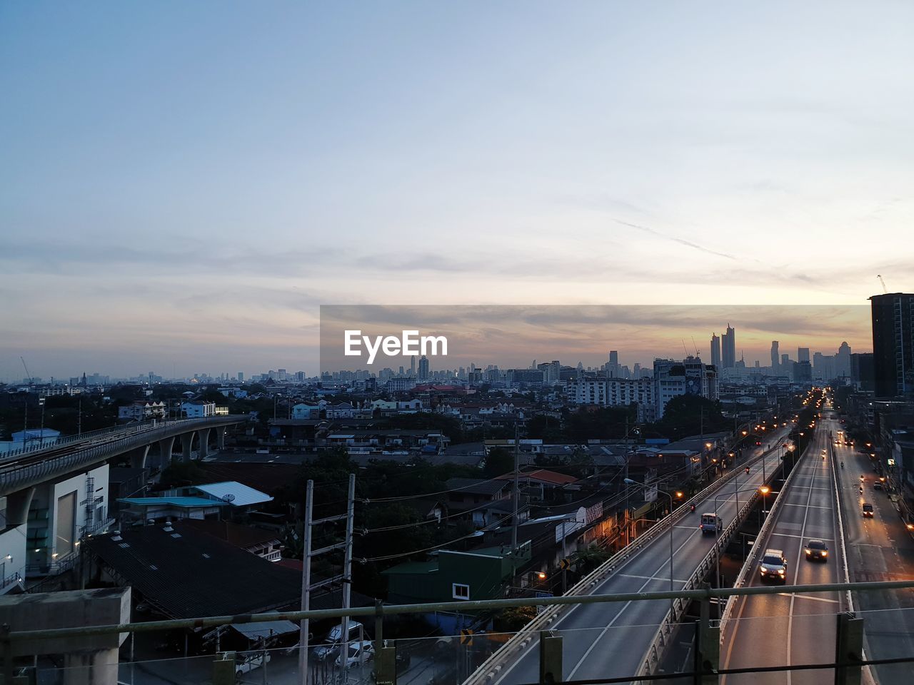 HIGH ANGLE VIEW OF ILLUMINATED BUILDINGS IN CITY AGAINST SKY