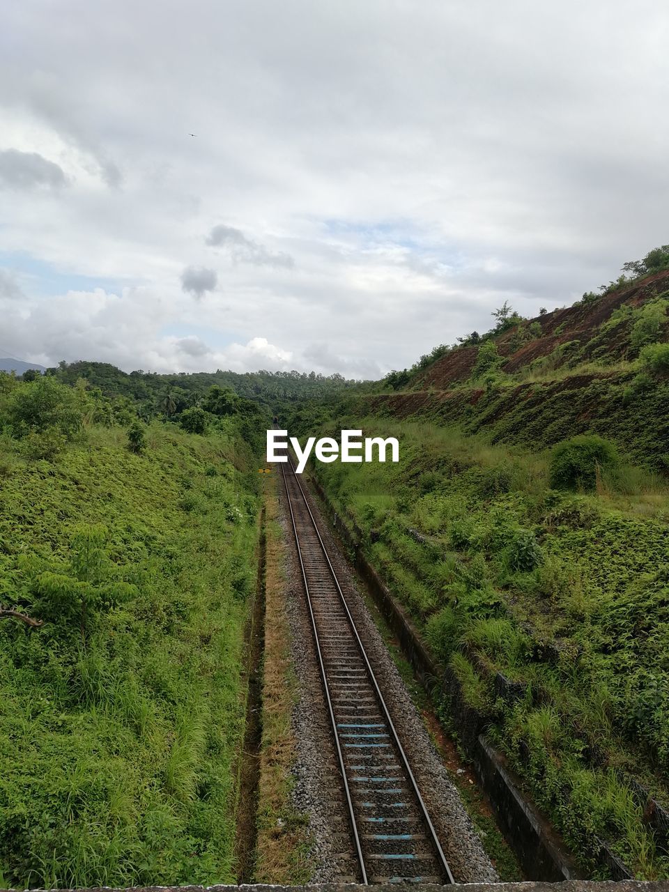 Railroad tracks on field against sky