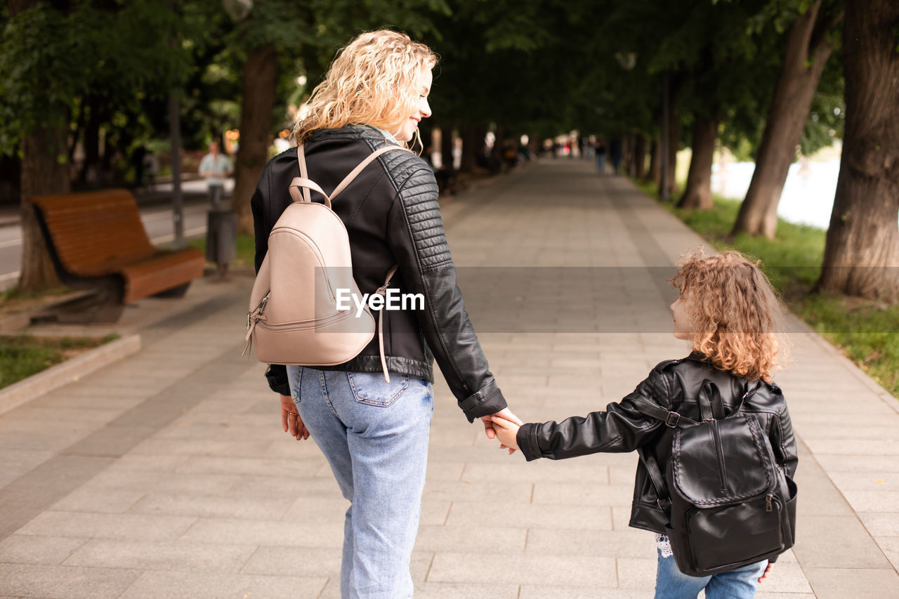 Rear view of women walking on footpath