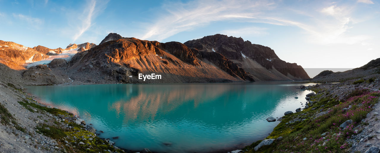 PANORAMIC VIEW OF LAKE BY SNOWCAPPED MOUNTAINS AGAINST SKY