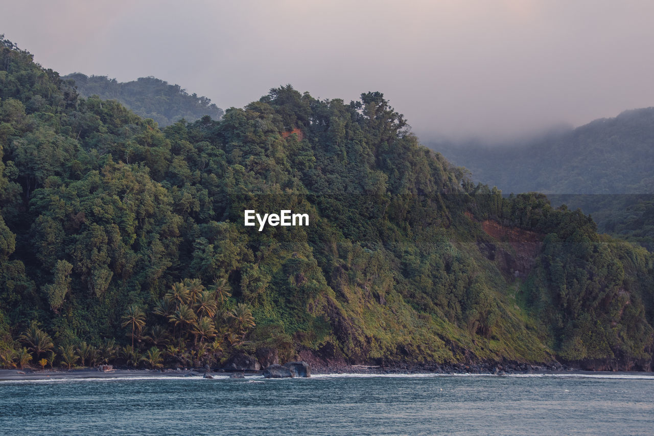 Scenic view of sea and mountains against sky