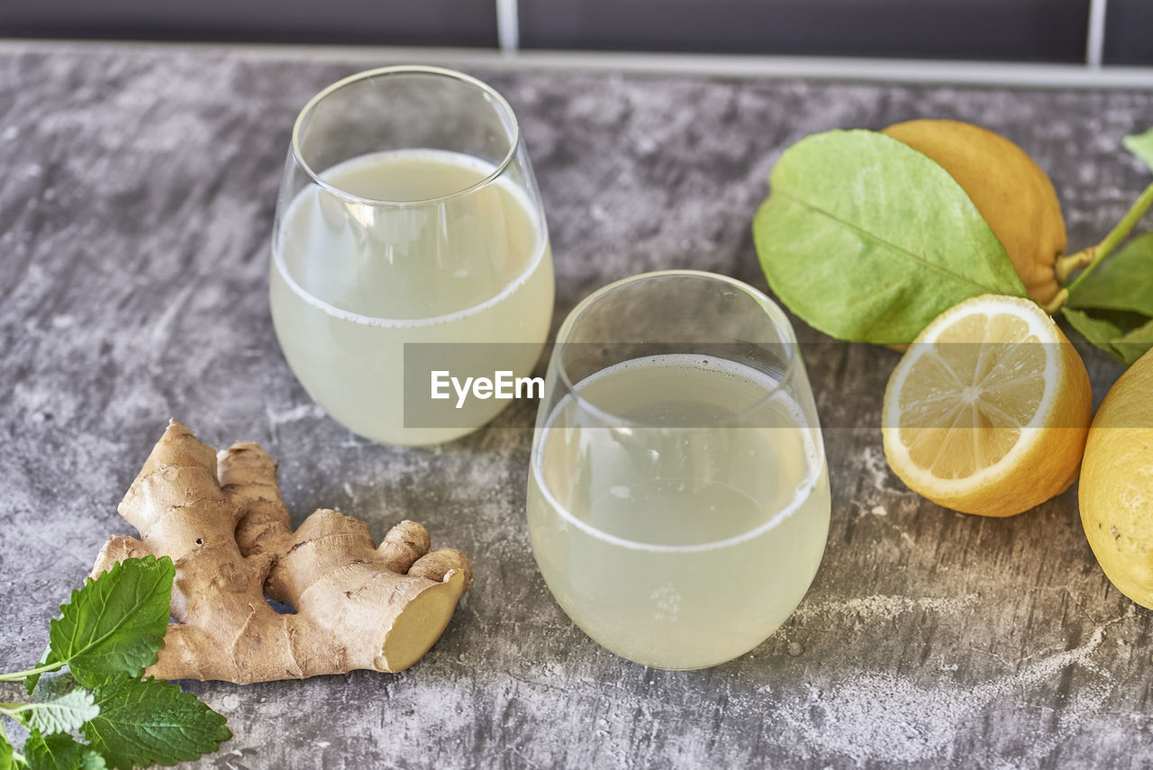 food and drink, food, citrus fruit, fruit, healthy eating, lemon, citrus, freshness, glass, drinking glass, refreshment, drink, leaf, household equipment, wellbeing, produce, lime, herb, indoors, plant, plant part, no people, wood, slice, table, nature, ingredient, still life, studio shot, high angle view