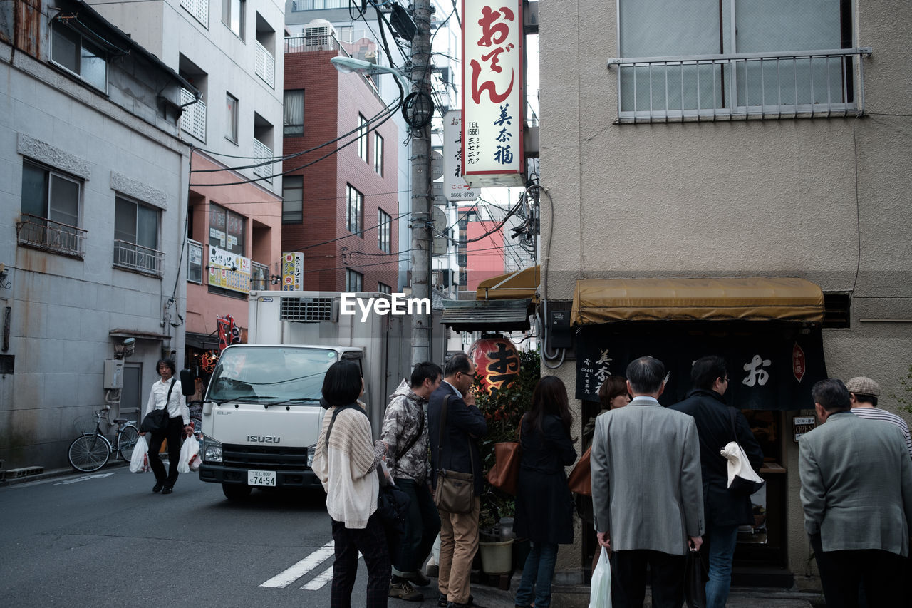 GROUP OF PEOPLE IN FRONT OF BUILDING